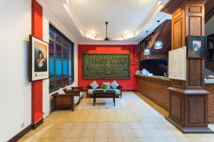 暹粒Sihariddh BnB Villa的一间设有红色墙壁和沙发的餐厅和一间酒吧