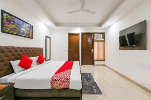 新德里OYO 72284 Premium Rooms Chhatarpur的一间卧室配有一张带红色枕头的大床