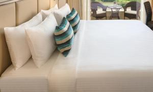 诺伊达Sandal Suites by Lemon Tree Hotels的一张白色的床,上面有枕头