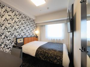 东京APA Hotel Nihombashi Bakuroyokoyama Ekimae的酒店客房设有床和窗户。