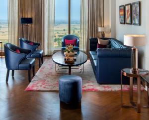诺伊达Sandal Suites by Lemon Tree Hotels的带沙发和桌椅的客厅