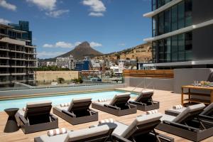 开普敦AC Hotel by Marriott Cape Town Waterfront的一座带躺椅的建筑屋顶上的游泳池