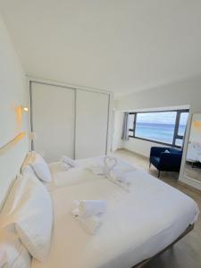 阿雷西费Apartamentos Arrecife Playa的卧室设有一张大白色的床和大窗户