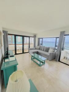阿雷西费Apartamentos Arrecife Playa的客厅配有沙发和桌子