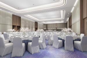 马尼拉Lanson Place Mall of Asia Manila的宴会厅配有白色的桌子和白色的椅子