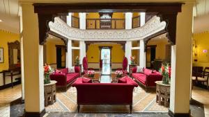 拉合尔Heritage Luxury Suites All Suite Hotel的大堂设有红色家具和黄色墙壁