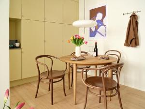 哥本哈根Apēron Apartment Hotel的餐桌和椅子,花瓶