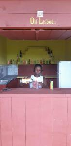 PrincipePousadinha Mar Ave Ilha的坐在餐厅粉红色柜台上的女人