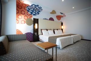 筑波贝斯特兰德酒店的酒店客房,设有两张床和一张沙发