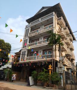 暹粒Beat Hotel Siem Reap的一条高大的白色建筑,在街上设有阳台
