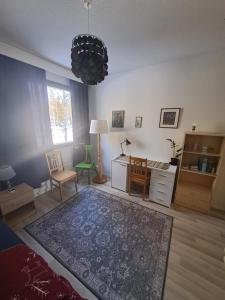 罗瓦涅米Room in Polar Circle的客厅配有地毯、桌子和书桌。