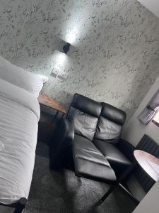 汤顿Woolaway的一间卧室配有一张床和一张黑色皮椅