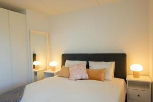 哥本哈根Penthouse - Amazing views & hygge的卧室配有带两盏灯的白色床