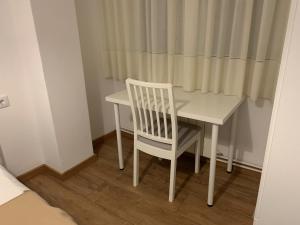拉科鲁尼亚Vibes Coruña-Outeiro 293的窗帘旁的白色桌子和椅子