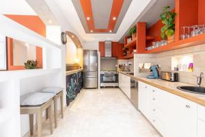 马赛La petite Toscane de Marseille的一个大厨房,配有橙色的墙壁和白色的橱柜