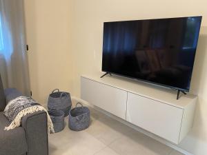 伊夫雷亚MyVilla - Ivrea via Jervis 22b的客厅配有白色橱柜上的平面电视