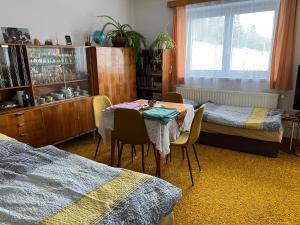 KošťálovPřízemí rodinného domu的一间卧室配有桌子、两张床和窗户。