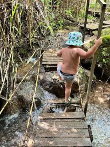 哈戈什里姆מעיין על הנחל - נופש בקיבוץ的一个小男孩爬上木桥