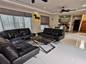 邦萨雷Talay Sawan Pool Villa 27-12的客厅配有真皮沙发和桌子