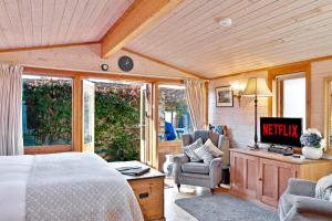 HurstpierpointThe Lodge - Luxury Lodge with Super King Size Bed, Kitchen & Shower Room的卧室配有一张床、一张桌子和椅子