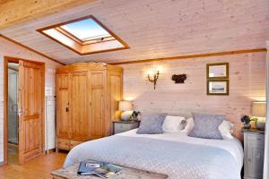 HurstpierpointThe Lodge - Luxury Lodge with Super King Size Bed, Kitchen & Shower Room的一间卧室配有一张床和天窗