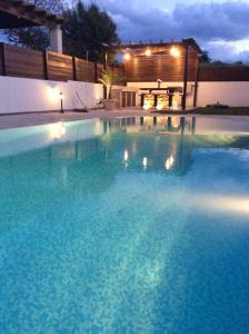 波利斯Dream House Latchi Villa的一座大型游泳池,晚上有一座房子,