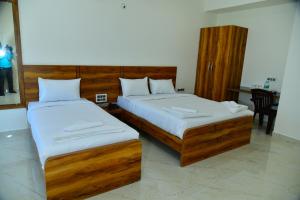 班加罗尔RK COMFORTS的一间卧室配有两张带白色床单的床