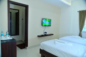 班加罗尔RK COMFORTS的酒店客房设有两张床和一台墙上的电视。