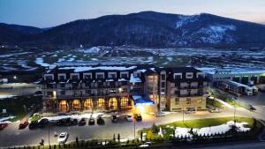 古拉哈莫卢洛伊Hotel Club Bucovina Resort & Spa的一座大型建筑,前面设有停车场