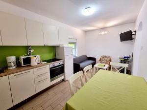 巴斯卡ARA-ZAROK的厨房配有白色橱柜、桌子和用餐室。