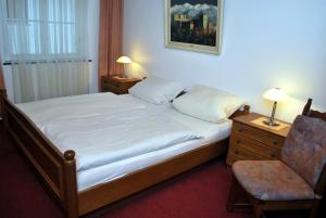 巴特萨尔茨乌夫伦豪斯莫尔斯酒店的卧室配有一张床和一把椅子,墙上挂着一张照片