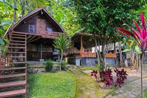 LukOYO 92419 Rejeng Homestay Near Kerta Gangga Waterfall的花园中间的木屋