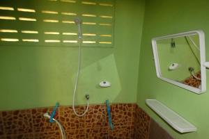 Ban Ao YaiAo Yai Homestay的绿色浴室设有淋浴和镜子