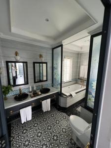 Phú ThọVườn Vua Resort & Villas的浴室配有两个盥洗盆和浴缸。