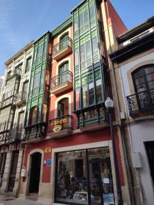 阿维莱斯Hostal la Fruta Nueva apertura的街道上一座带五颜六色窗户和阳台的建筑