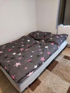 阿巴斯塔特Gemütliche Wohnung in Happenbach的一张床上的黑色毯子,上面有星星