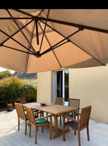 内维兹maison de vacances ninette的大伞下一张木桌和椅子