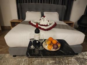 伯利恒Lotus Boutique Hotel的床上装有一盘水果和酒杯的托盘