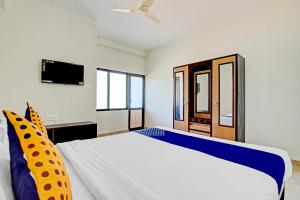 JadkalSPOT ON Advaitha Boarding And Lodging的一间带大床和电视的卧室