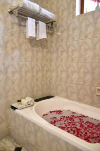 克久拉霍Greenwood Hotel的浴室设有红色花瓣覆盖的浴缸。
