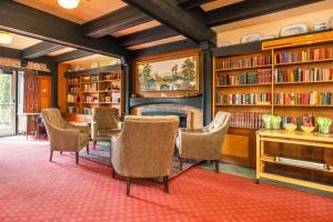 Saanichton摇摆狗品质酒店的图书馆配有椅子、书架和壁炉