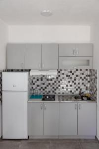 克拉列沃Đerdan Garden apartments的白色的厨房配有白色橱柜和电器
