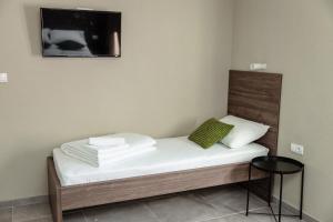 克拉列沃Đerdan Garden apartments的一张配有白色床单的床和墙上的电视