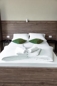 克拉列沃Đerdan Garden apartments的一张带白色毯子和枕头的床