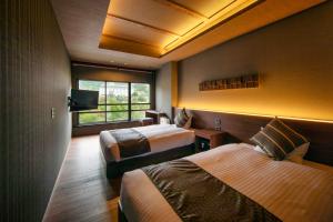 云仙市云仙福田酒店的酒店客房设有两张床和窗户。