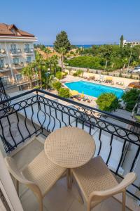 凯麦尔大洋海滩度假酒店的一个带桌椅的阳台和一个游泳池