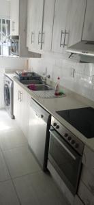 韦斯特布鲁克Blue Largo Sea View的白色的厨房设有水槽和炉灶。