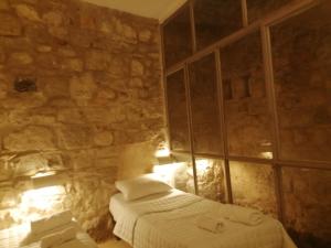 达纳Dana Gardens Hotel的一间卧室设有一张床和石墙