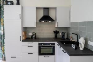 Roelofarendsveen5 persons Holiday Home Comfort的厨房配有白色橱柜和炉灶烤箱。