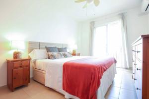 贝纳尔马德纳Ap. con vistas panorámicas的白色卧室配有一张带红色毯子的大床